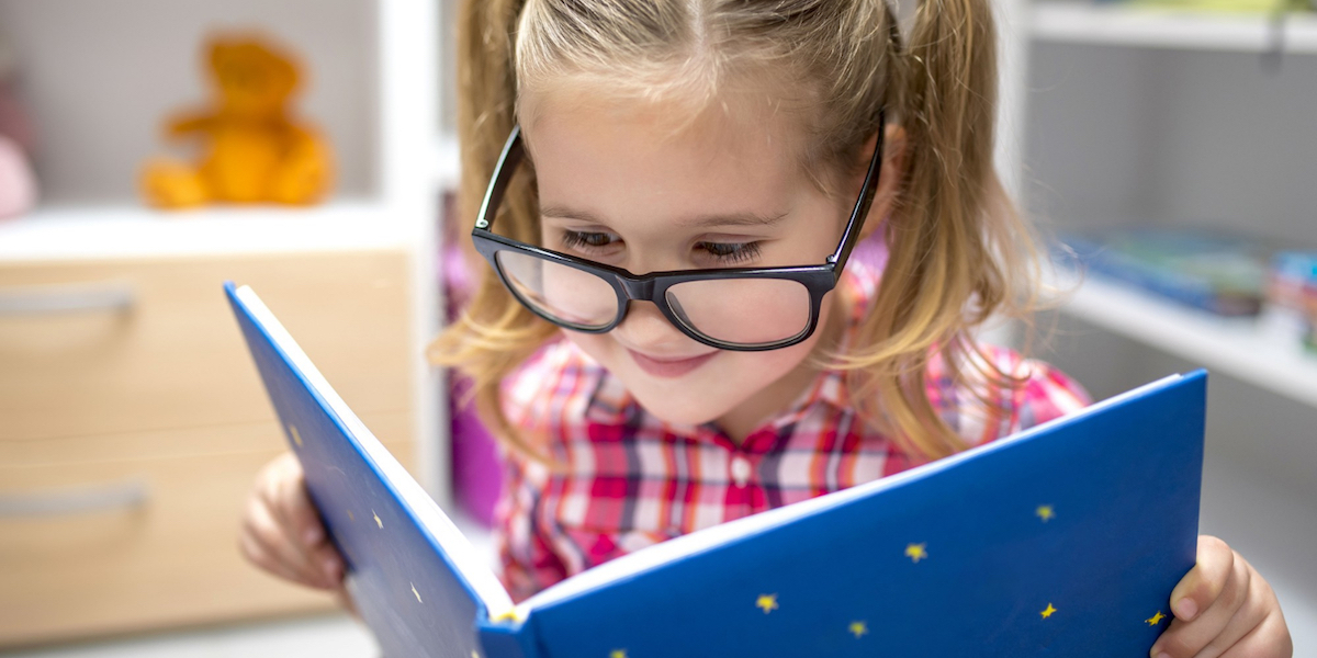 bambina legge libro divertente